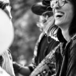 Group of adults enjoying laughter and interaction at an outdoor event.